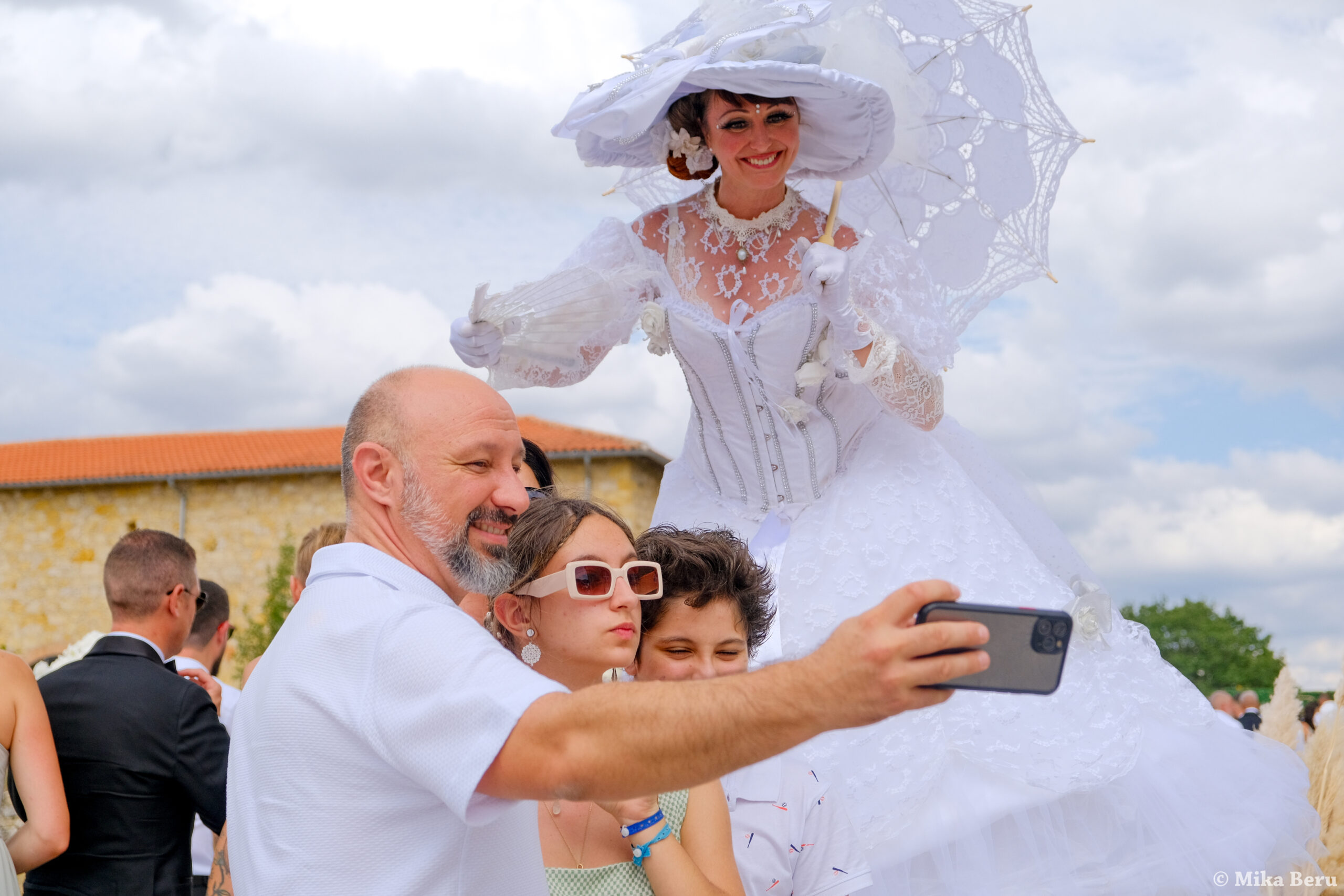 Animation de mariage avec artiste en costume blanc et mariés en séance photo